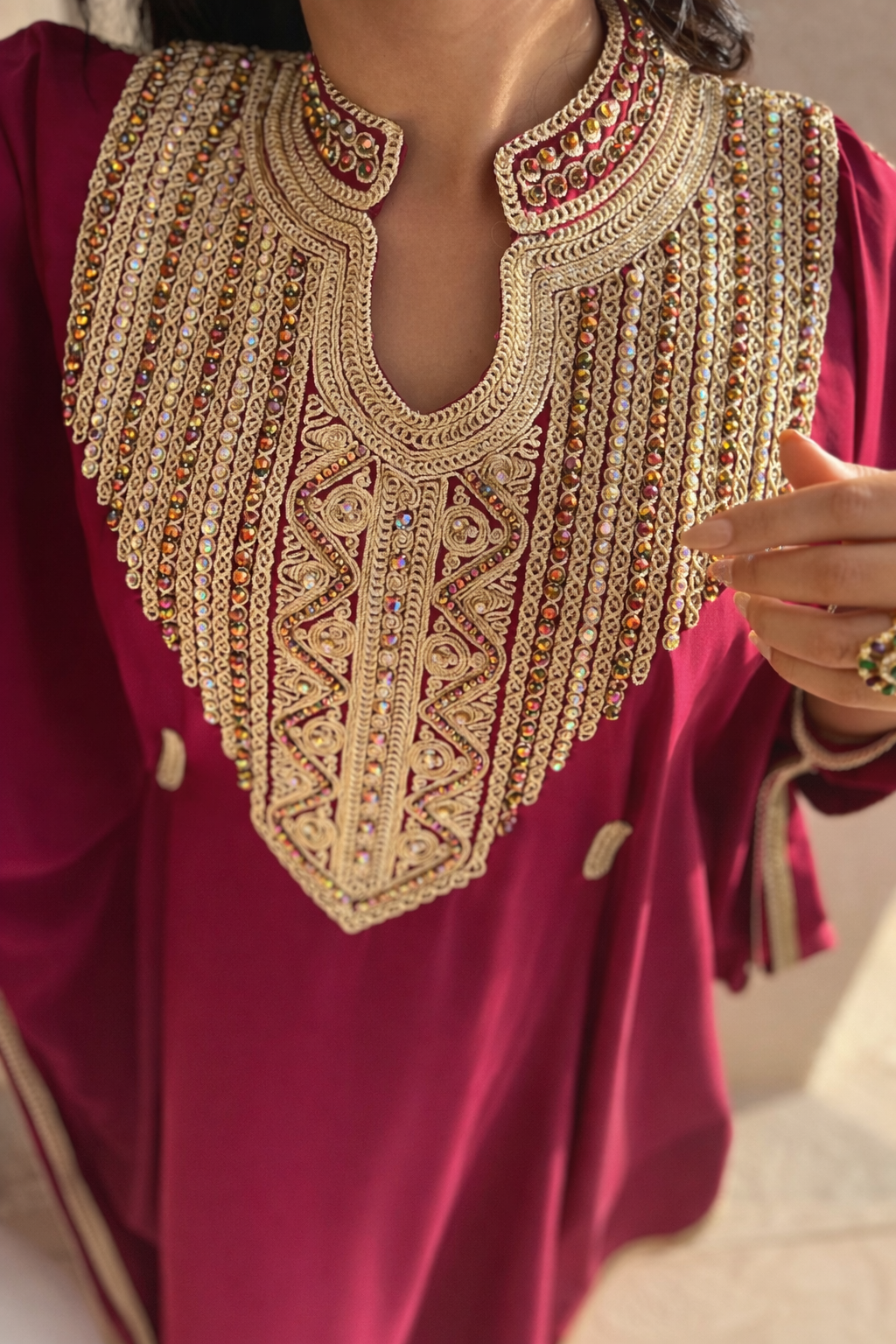High-definition close-up of the gold thread and crystal embellishments on the Sultana Fuchsia Kaftan neckline.