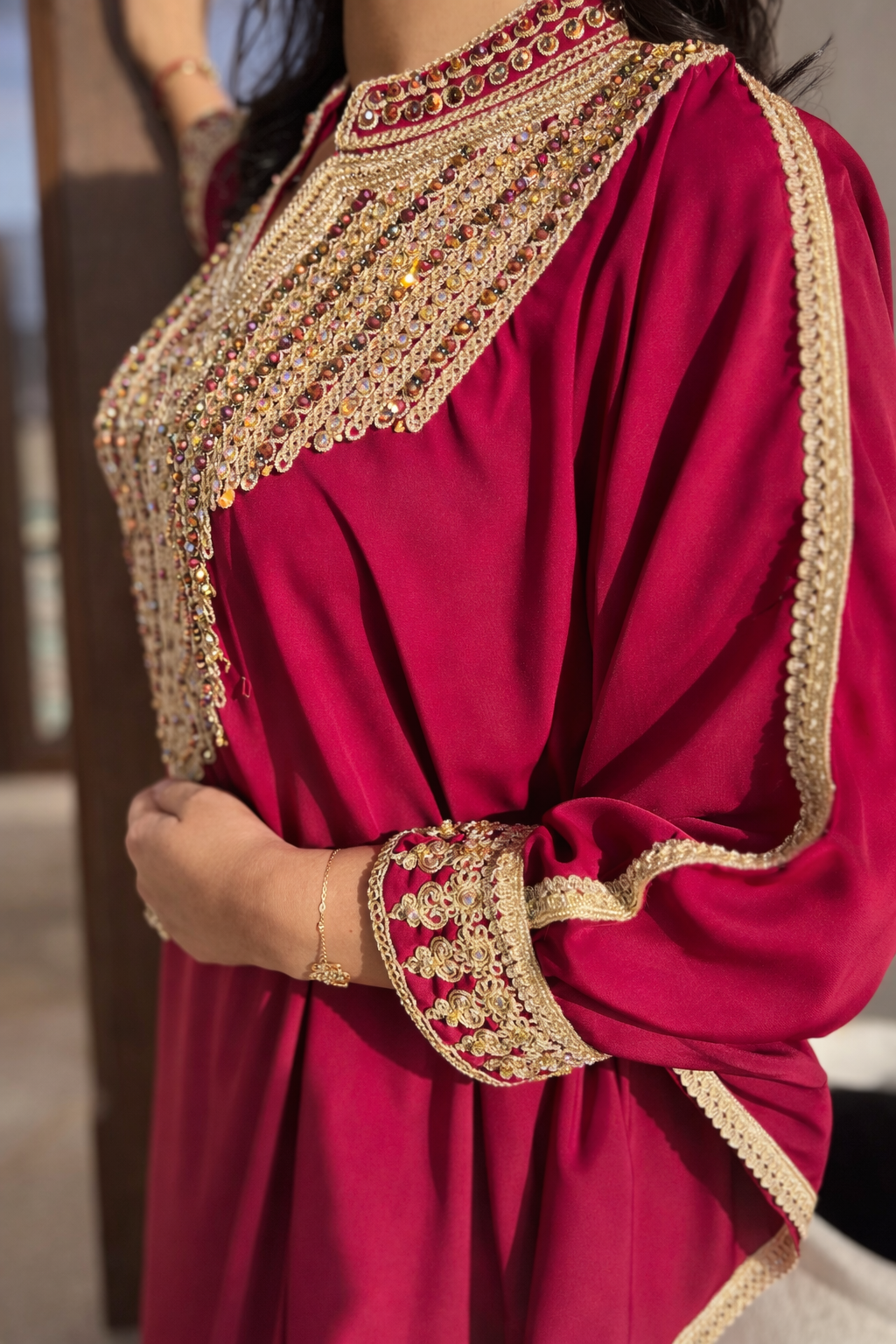 Side view of the Maison Nelya Sultana Fuchsia Kaftan showing the elegant drape and gold trim.