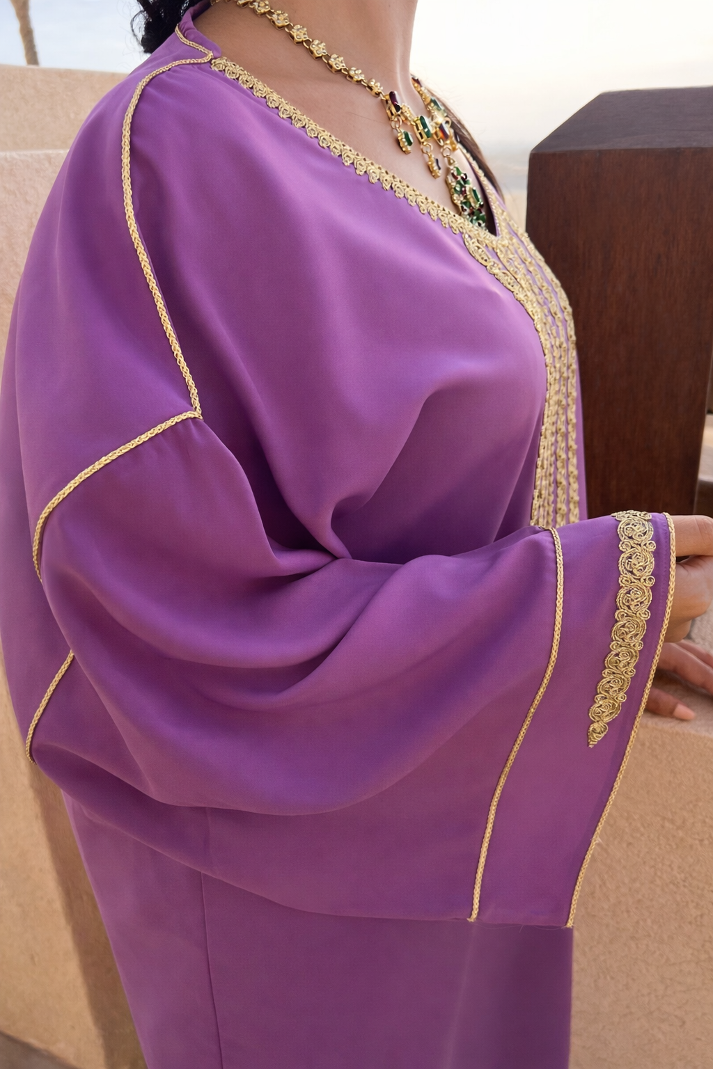 Detailed shot of the intricate gold thread work on the sleeve cuffs of the Maison Nelya emerald kaftan.