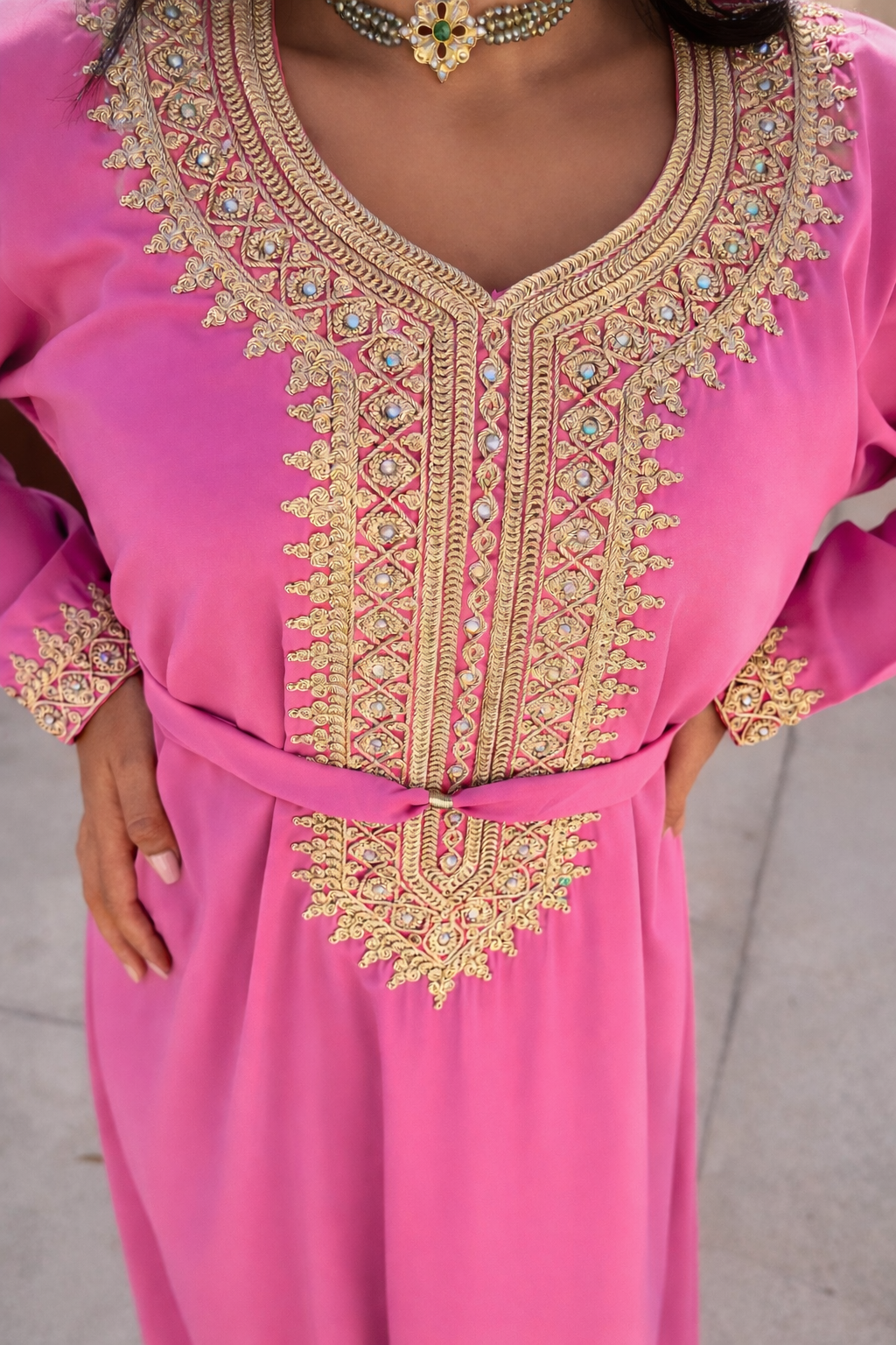 Detailed close-up of the handcrafted gold embroidery and crystals on the bodice of the rose pink Maison Nelya kaftan.